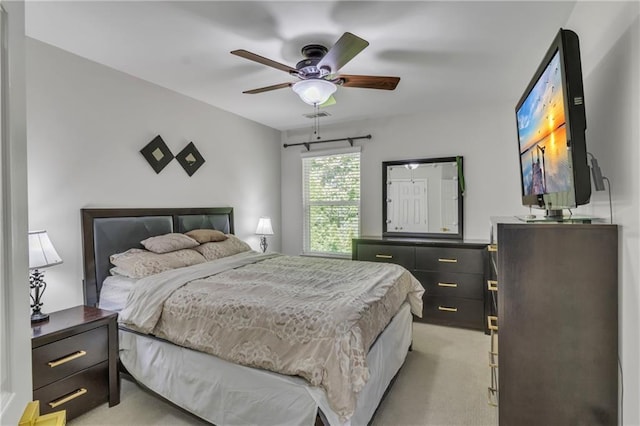 bedroom featuring light carpet and a ceiling fan