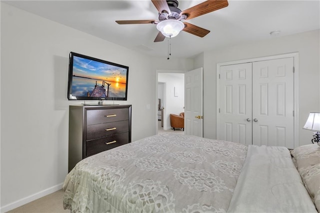 carpeted bedroom with a closet, baseboards, and a ceiling fan