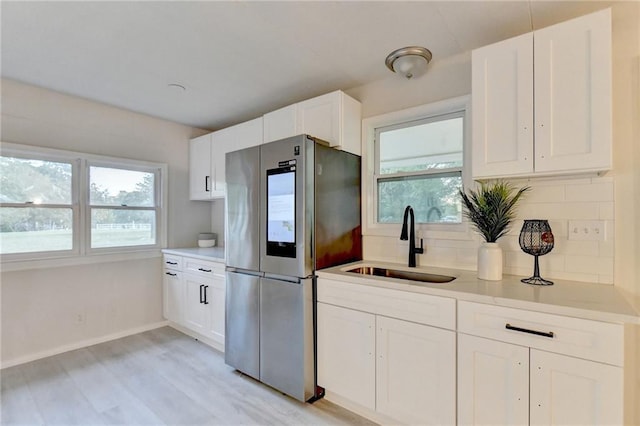 kitchen with a wealth of natural light, a sink, backsplash, and smart refrigerator