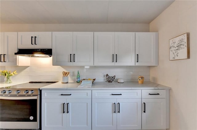 kitchen with tasteful backsplash, white cabinets, under cabinet range hood, light countertops, and electric stove