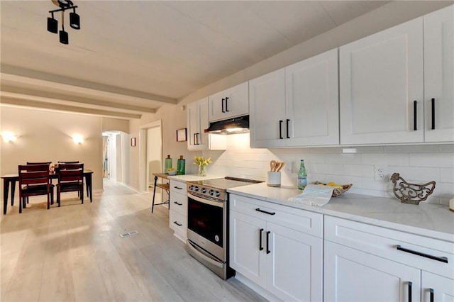 kitchen featuring under cabinet range hood, white cabinetry, electric range, and decorative backsplash