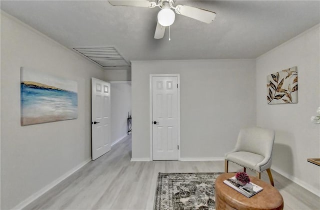 living area with light wood-style floors, baseboards, visible vents, and ceiling fan