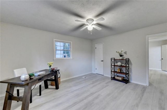 office space featuring light wood-style flooring, ceiling fan, and baseboards