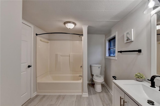 bathroom with a textured ceiling, vanity, toilet, shower / bath combination, and wood finished floors