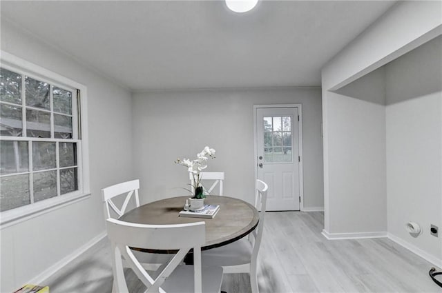 dining area with light wood-style flooring and baseboards