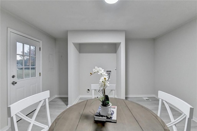 dining space featuring wood finished floors and baseboards