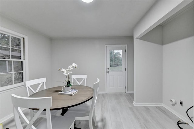 dining space featuring light wood-style flooring and baseboards