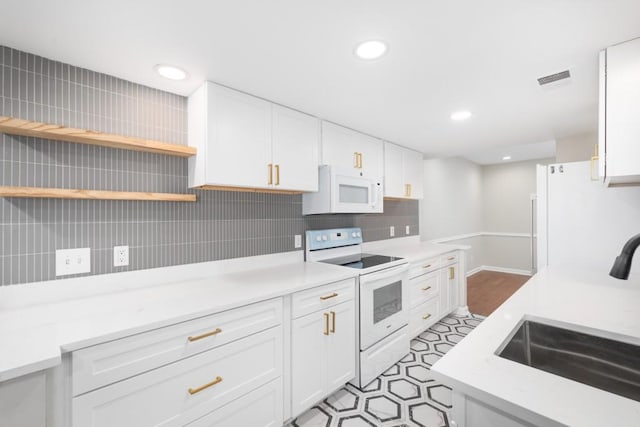 kitchen featuring sink, white cabinets, and white appliances