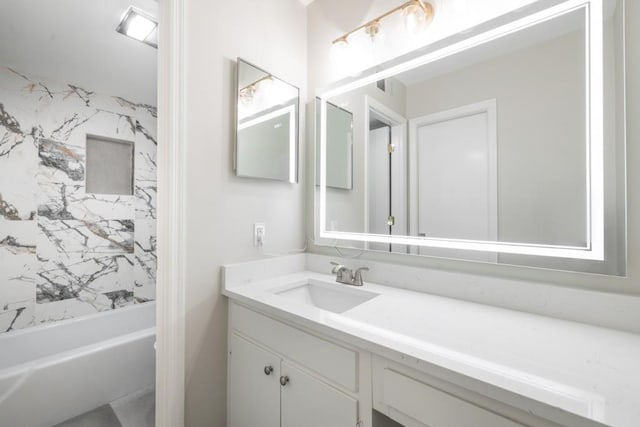 bathroom featuring vanity and tiled shower / bath