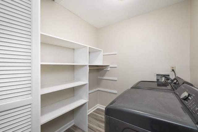 clothes washing area with hardwood / wood-style flooring and separate washer and dryer