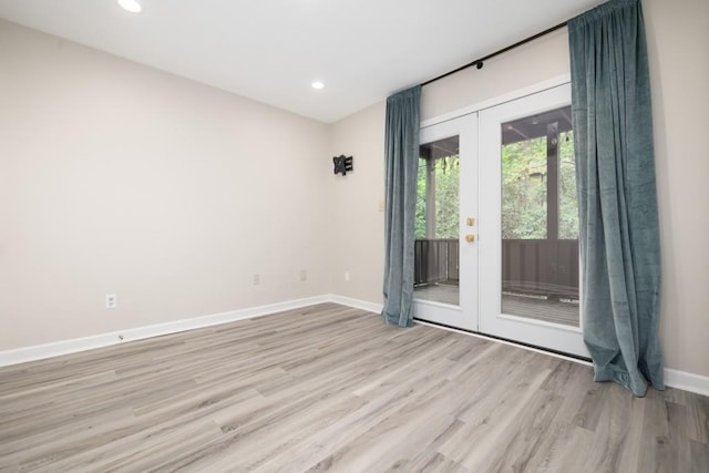 empty room featuring french doors and light wood-type flooring