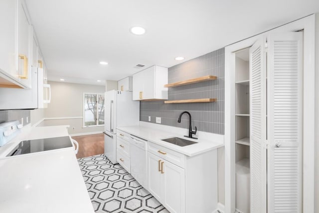 kitchen with white cabinets, backsplash, sink, and white appliances