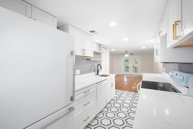 kitchen featuring white appliances, white cabinets, french doors, sink, and ceiling fan