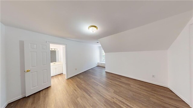 bonus room featuring wood-type flooring and vaulted ceiling