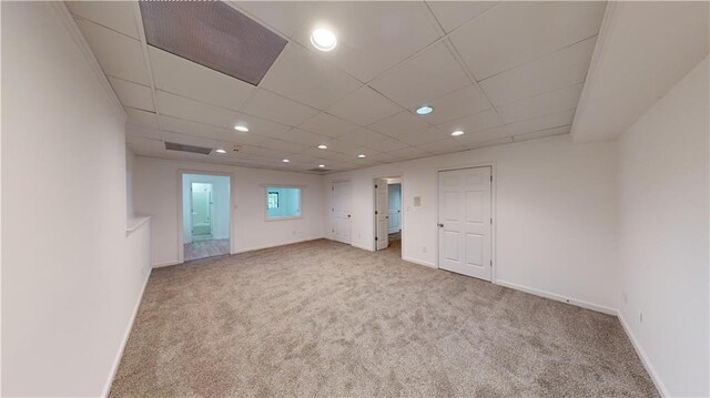 carpeted empty room with a drop ceiling