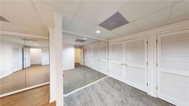 basement with a paneled ceiling and carpet floors