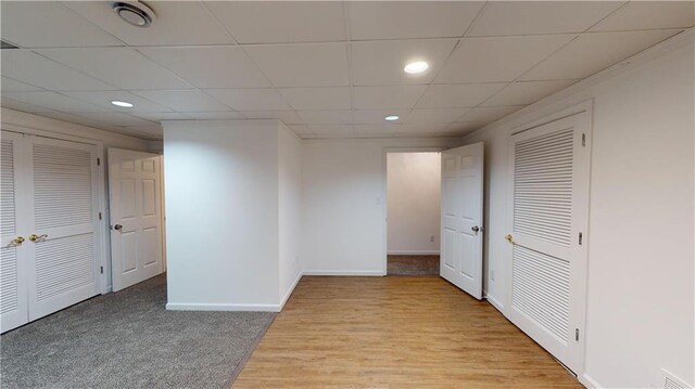 hall featuring a paneled ceiling and light hardwood / wood-style floors