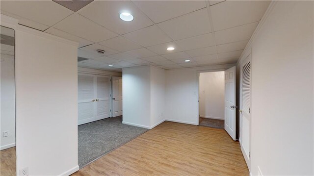 spare room with a drop ceiling and hardwood / wood-style flooring