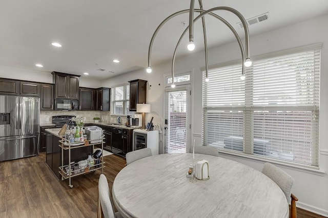 dining area featuring dark wood finished floors, wine cooler, and recessed lighting