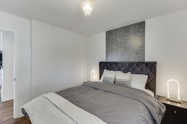 bedroom with wood finished floors and baseboards
