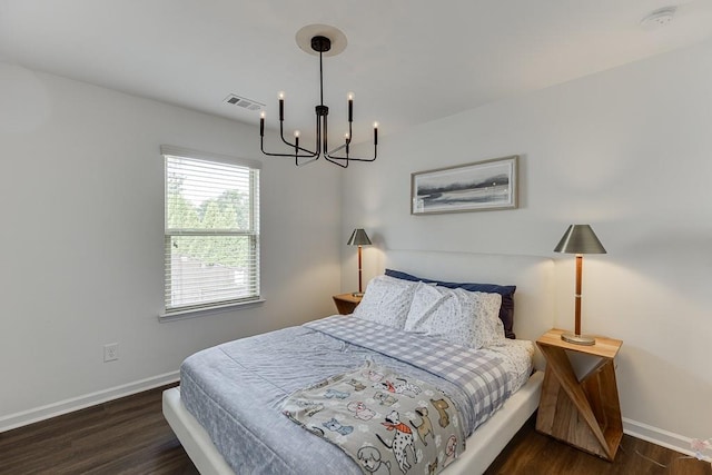 bedroom featuring a chandelier, baseboards, and wood finished floors
