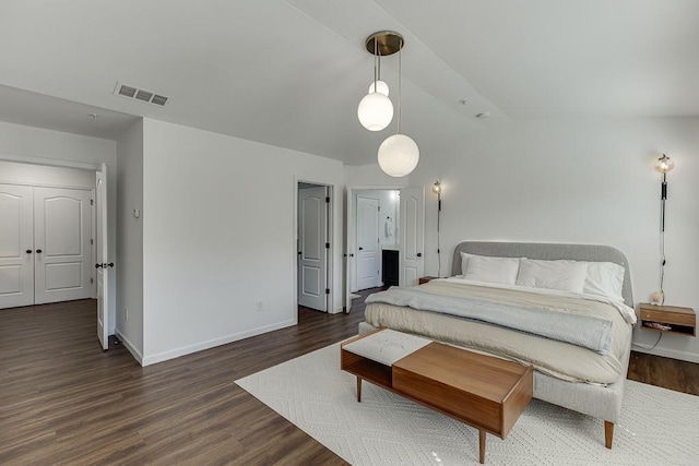 bedroom with wood finished floors, baseboards, and vaulted ceiling