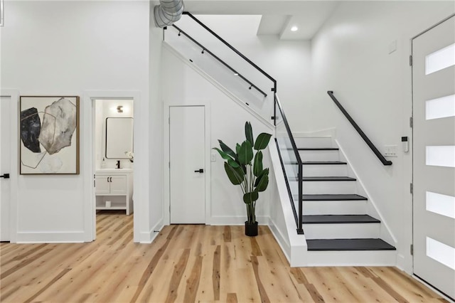 entrance foyer with light wood-style floors, recessed lighting, baseboards, and stairs