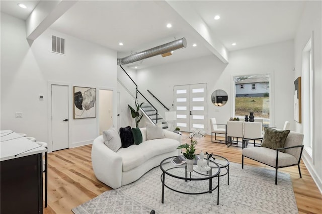 living area featuring light wood-style floors, stairs, visible vents, and recessed lighting