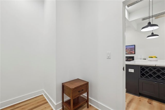 interior space featuring hanging light fixtures, light wood finished floors, and baseboards