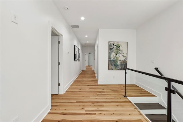 corridor featuring recessed lighting, visible vents, attic access, light wood-type flooring, and baseboards