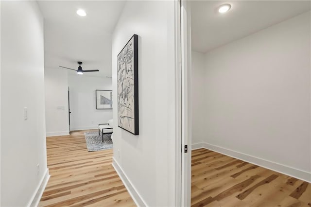 hall with light wood-style floors, recessed lighting, and baseboards