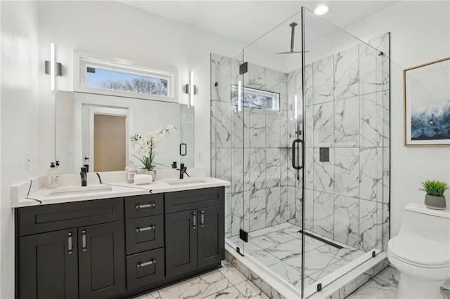 full bath with marble finish floor, double vanity, a sink, and toilet