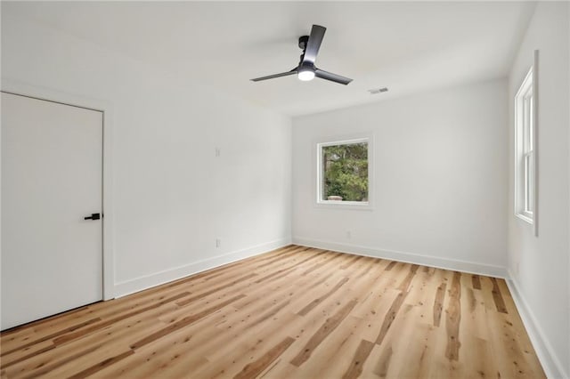 empty room featuring visible vents, ceiling fan, baseboards, and wood finished floors