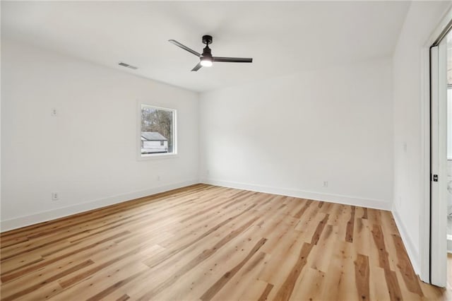 unfurnished room featuring baseboards, visible vents, ceiling fan, and light wood finished floors