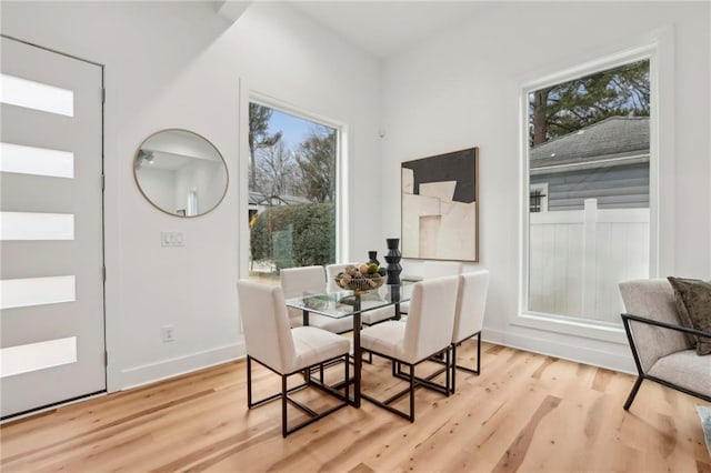 dining space featuring light wood-style flooring and baseboards