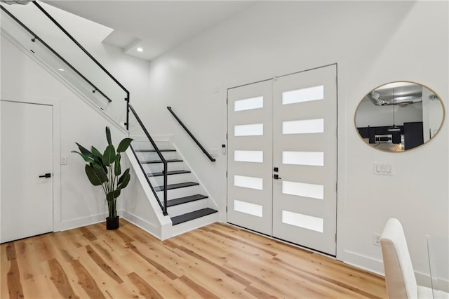 foyer entrance featuring light wood finished floors, recessed lighting, stairs, and french doors