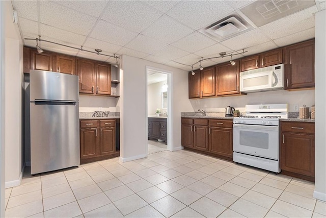 1402 Mclendon Dr, Decatur, GA 30033 - kitchen featuring white appliances, a paneled ceiling, light tile patterned flooring, stone countertops, and open shelves