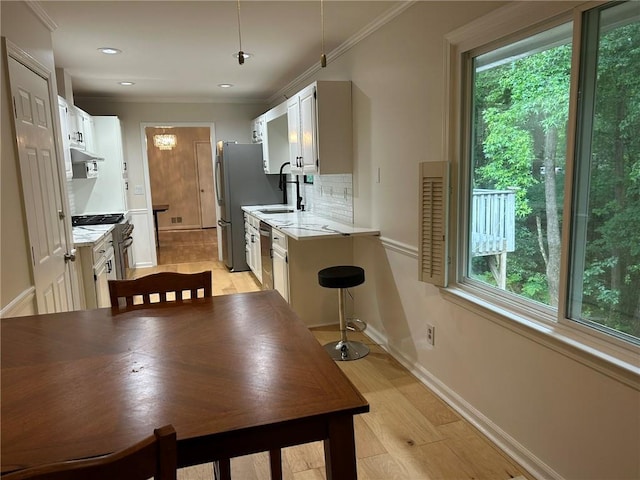 1402 Mclendon Dr, Decatur, GA 30033 - kitchen with backsplash, light countertops, white cabinets, ornamental molding, and recessed lighting