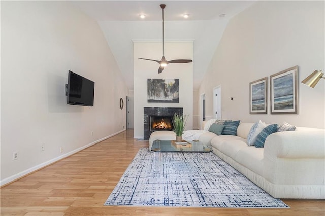 1402 Mclendon Dr, Decatur, GA 30033 - living room with wood finished floors, a ceiling fan, a premium fireplace, and a towering ceiling