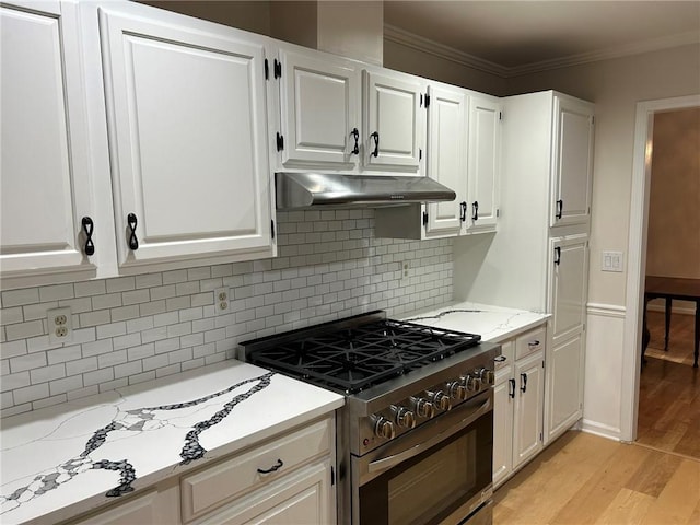 1402 Mclendon Dr, Decatur, GA 30033 - kitchen featuring high end stove, under cabinet range hood, white cabinets, light wood-style floors, and ornamental molding