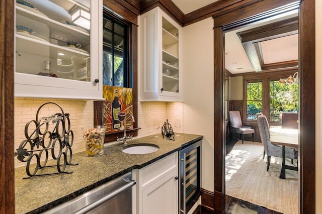 bar with stainless steel dishwasher, beverage cooler, crown molding, and a sink