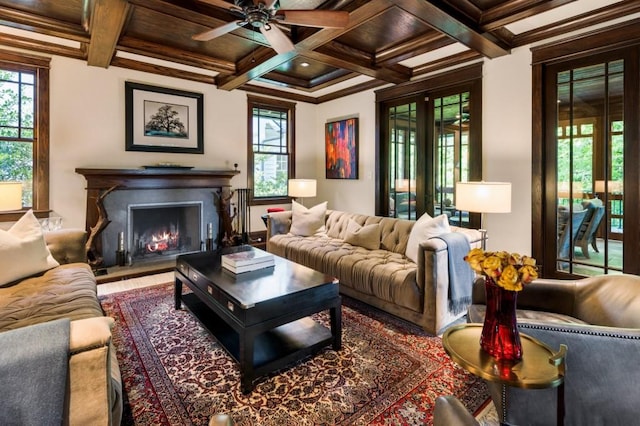 living area featuring french doors, coffered ceiling, beamed ceiling, and a lit fireplace