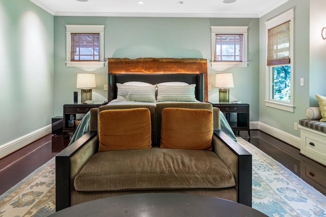 bedroom featuring ornamental molding, wood finished floors, and baseboards