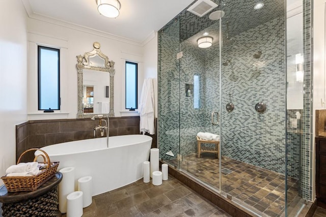 full bathroom featuring a stall shower, visible vents, ornamental molding, a freestanding tub, and tile walls