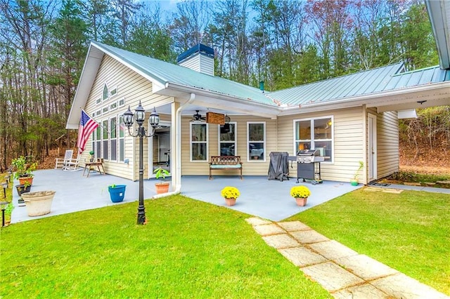 back of property with a lawn, ceiling fan, and a patio