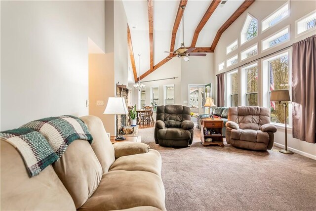 living room with ceiling fan, beam ceiling, a stone fireplace, and high vaulted ceiling