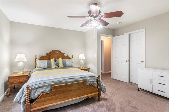 carpeted bedroom featuring ceiling fan and a closet