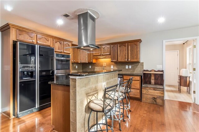 kitchen featuring island exhaust hood, tasteful backsplash, a kitchen island, stainless steel dishwasher, and sink