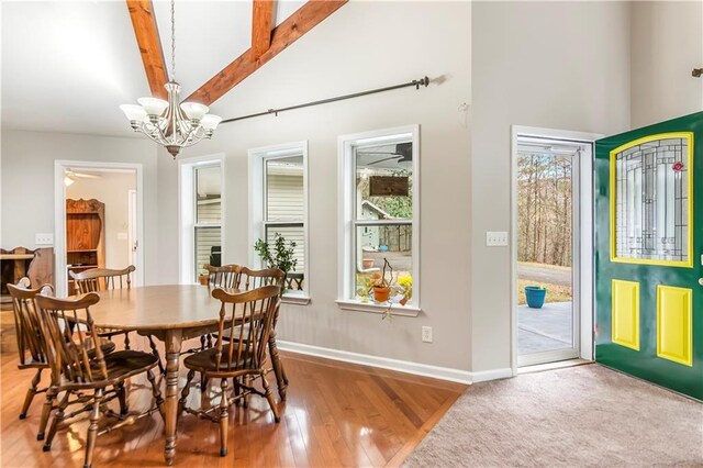 dining room featuring vaulted ceiling with beams, light wood-type flooring, and ceiling fan with notable chandelier