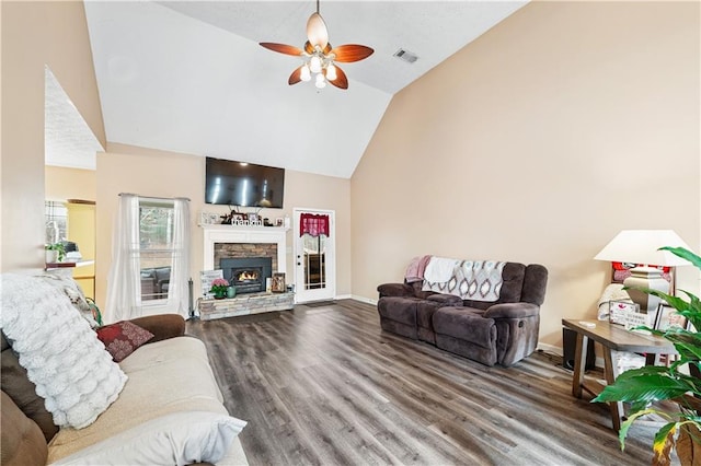 living room featuring ceiling fan, a stone fireplace, lofted ceiling, and wood-type flooring